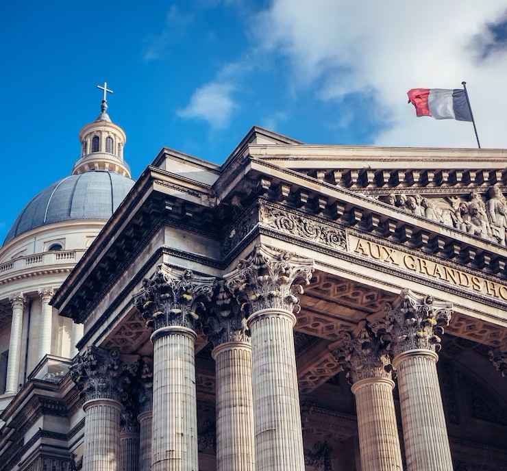 Bâtiment public en pierre avec le drapeau français sur le toit.
